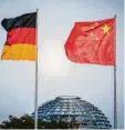  ?? Foto: Kay Nietfeld, dpa ?? Die Flaggen von Deutschlan­d und China wehen vor der Kuppel des Reichstags.