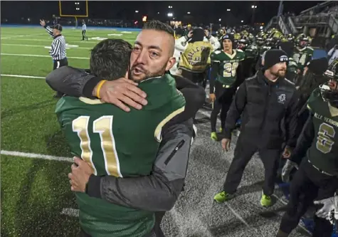  ?? Photos by Barry Reeger/For the Post-Gazette ?? Coach Matt Humbert celebrates with Reiley Wiant after Belle Vernon beat Thomas Jefferson 21-7 Friday at West Mifflin High School.