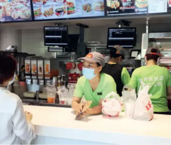  ??  ?? A customer orders food at a fast food chain outlet in Guangzhou, Guangdong Province in south China, on April 28, 2020. The chain started serving artificial
meat products in several cities in China that day