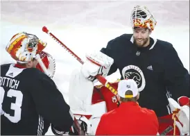  ?? Canadian Press photo ?? Calgary Flames goalie Jacob Markstrom, right, talks with goaltendin­g coach Jordan Sigalet, centre, as goalie David Rittich looks on during a training camp practice in Calgary.