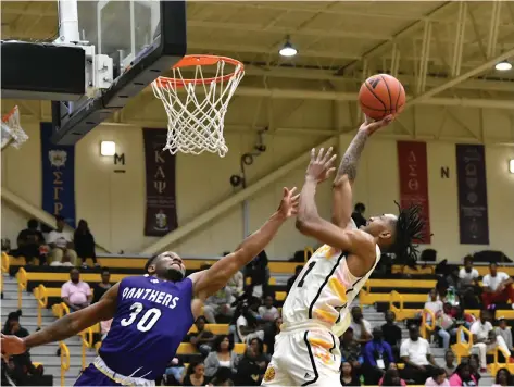  ?? (Pine Bluff Commercial/I.C. Murrell) ?? Kylen Milton of UAPB scoops in a layup over Andre Nunley of Prairie View A&M in the first half on Saturday at H.O. Clemmons Arena.
