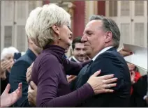  ?? The Canadian Press ?? Quebec Premier Francois Legault, right, hugs his wife Isabelle Brais after he was sworn in during a ceremony at the National Assembly, Thursday, at the legislatur­e in Quebec City.