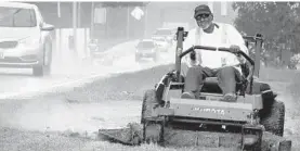  ?? AMY DAVIS/BALTIMORE SUN ?? Tuesday’s early afternoon rain forced Ed Bernard, who was mowing the median strip along Ritchie Highway, to quit early. This year has seen plenty of work interrupti­ons for him.