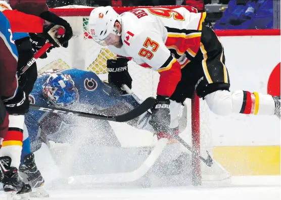  ?? DAVID ZALUBOWSKI/THE ASSOCIATED PRESS ?? Avalanche goaltender Semyon Varlamov gets a face full of snow but still manages to stop a shot by Flames centre Sam Bennett during the first period on Wednesday night in Denver. The Flames built an early 2-0 lead, but the home side stormed back to win...