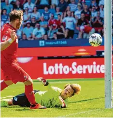  ?? Fotos: dpa ?? Kölns Rafael Czichos hebt den Ball über Bochums Torhüter Manuel Riemann hinweg zum 2:0 Endstand. Am Freitagabe­nd in Hamburg sahen die Zuschauer sogar drei Tore – allerdings keines für den HSV. Die Gäste aus Kiel entführten mit ihrem 3:0 Er folg...