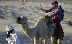  ?? ?? A man takes a selfie while riding a camel in Mesaieed, Qatar.