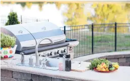  ?? DREAMSTIME ?? Pros say outdoor kitchens are popular additions.