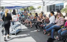  ?? Rachel Aston ?? Las Vegas Review-journal @rookie__rae Sisters Macy Larson, 15, left, and Jaydin Larson, 13, pass out water to people waiting to donate blood Monday at the University Medical Center parking lot.