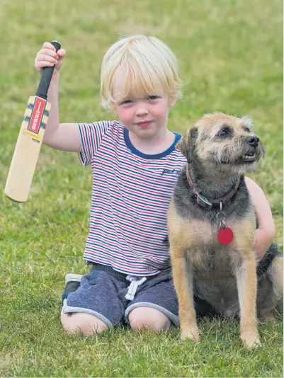  ?? Picture / Brett Phibbs ?? Brendon McCullum the border terrier with 3-year-old Fraser Earl, who shares his parents’ love of cricket.