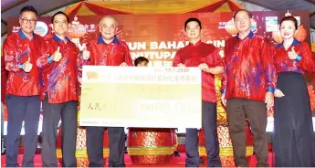  ??  ?? Liang (third right) handing over the mock cheque for RMB60,000 to Goh. Also seen, from left, are Chua, Fung, Yong and Wong.