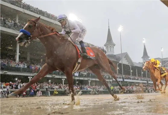  ?? MORRY GASH/ AP ?? Mike Smith rides Justify to a 2 ½ - length victory over Good Magic in the Kentucky Derby on Saturday. The 5- 2 favorite paid $ 7.80 to win and finished in 2: 04.20.