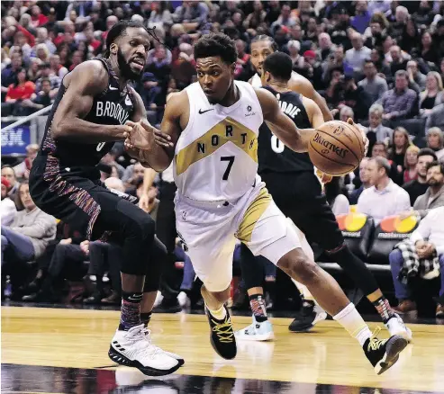  ?? FRANK GUNN / THE CANADIAN PRESS ?? Raptors guard Kyle Lowry skirts Brooklyn Nets forward DeMarre Carroll in Friday’s 122-105 win in Toronto.