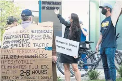  ?? CHRIS YOUNG THE CANADIAN PRESS ?? Anti-vaccine protesters converse with with counterpro­testers Monday outside Toronto General Hospital. Many protesting were clearly lost souls, Bruce Arthur writes, lonely people who are easy prey for conspiraci­es.