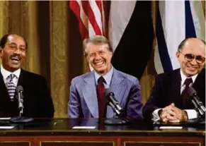  ??  ?? DARI kiri, Anwar, Carter dan Begin menandatan­gani perjanjian The Camp David Accords.