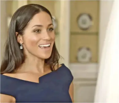  ??  ?? Happy memory: Meghan Markle studies her wedding dress in footage from the ITV show