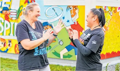  ?? Photos / Warren Buckland ?? Ebbett Park principal Kate Medlicott and NZSL communicat­or Nora Kirikiri showing off signs their students have been learning.