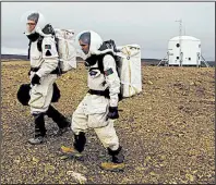  ?? Special to the Democrat-Gazette ?? Crew members explore Devon Island in the Canadian Arctic as part of a research project this summer to simulate the conditions of a Mars exploratio­n mission.