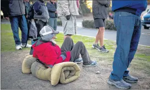  ?? AP PHOTO ?? Homeless people wait in line for a free meal in Dana Point, Calif. The number of homeless living in Orange County has climbed 8 percent over the last two years.