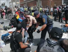  ??  ?? Rescue personnel help injured people after a car ran into a large group of protesters after a white nationalis­t rally in Charlottes­ville, Va.