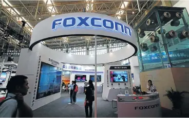  ?? /Reuters ?? Where to from here: Visitors take a look at a Foxconn booth at the World Intelligen­ce Congress in Tianjin, China, in May. The Taiwanese contract manufactur­er is seeking to reinvent itself.