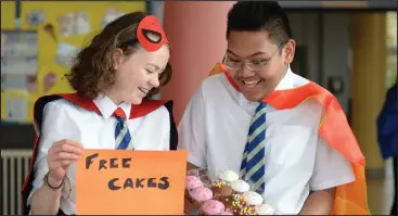  ??  ?? Lourdes Secondary is organising a Random Acts of Kindness competitio­n for its pupils. Third Year Pupils in superhero costumes Alex McLachlan and Jack Donnelly giving out free cakes Picture: Kirsty Anderson