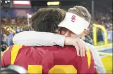  ?? Associated Press ?? USC quarterbac­k Caleb Williams (left) gets a hug from head coach Lincoln Riley after USC defeated UCLA 48-45 on Nov. 19 in Pasadena. Riley and Williams have turned the program around.