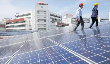  ?? TANAPHON ONGARTTRAK­UL ?? Rooftop solar panels are installed at Thammasat University, Rangsit campus.