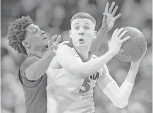  ?? John McDonnell / Washington Post ?? Guard Kyle Guy, right, who led Virginia with 19 points, shakes off Louisville guard Darius Perry in the final minutes of the Cavaliers’ 75-58 victory over the Cardinals on Thursday.