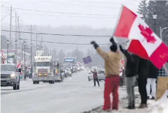  ?? THE CANADIAN PRESS ?? People protesting a COVID-19 vaccine mandate for cross-border truckers rally as a parade of trucks passes through Kakabeka Falls, near Thunder Bay, Ont., on Wednesday. The truck convoy is headed to Ottawa.