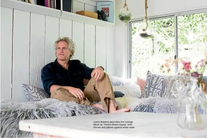  ??  ?? Jonno Roberts describes the cottage decor as ‘‘Venice Beach hippie’’ with throws and pillows against white walls.