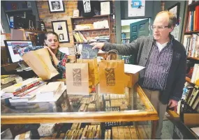  ?? DAN JANISSE ?? Dan Wells, owner of Biblioasis, and manager Tina Lyons prepare deliveries at the Windsor bookstore on Friday. Like many local businesses, they are doing e-commerce, curbside pickup and home deliveries during the COVID-19 threat.