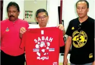  ??  ?? ROSDY (dari kanan) menyaksika­n Hasbullah sedang mengamati baju Kelab Penyokong Bolasepak Sabah dari Sandakan Mix yang dilancar secara rasmi di pejabat Persatuan Bolasepak Sabah (SAFA), di Likas pada Sabtu.