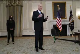  ?? EVAN VUCCI — THE ASSOCIATED PRESS ?? President Joe Biden holds a face mask after speaking about COVID-19in the State Dining Room of the White House in Washington on Tuesday. Vice President Kamala Harris is at left.