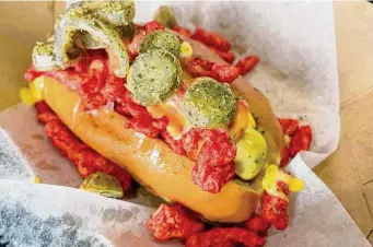  ?? ?? The Dogfather II: The Ratchet, with peppers, Hot Cheetos and queso, is one of many tricked-out menu items at the hot spot for hot dogs.