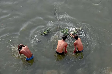  ?? PHOTO: REUTERS ?? Men bathe in the river Ganges in Kanpur, India.