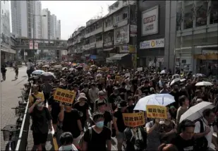  ?? AP PHOTO/KIN CHEUNG ?? Protesters hold up words that read: “Strict enforcing of law against smugglers of grey goods” as they march in Hong Kong on Saturday.