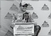  ?? [AP PHOTO] ?? Kyle Larson and his son Owen kneel behind the pole flag after qualifying Friday for Sunday’s NASCAR Sprint Cup series race in Brooklyn, Mich.