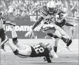  ?? Robert Gauthier Los Angeles Times ?? MELVIN GORDON of the Chargers hurdles over Raiders safety Karl Joseph during a second-half run Sunday in Oakland. Gordon rushed 18 times for 93 yards.