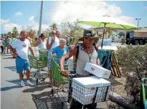  ?? REUTERS ?? People collect food, water, and supplies provided by the 26th Marine Expedition­ary Unit at a distributi­on point in Key West, Florida.