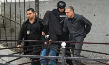  ?? Photograph: Srđan Stevanović/Getty ?? Police officers escort away a suspect after the attack.
