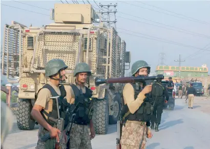  ?? AP ?? Troops leave after a shootout with militants on the outskirts of Peshawar on Saturday. Three Taleban militants were killed while two security personnel were injured in the pre-dawn encounter in the Chamkani area of Peshawar. —