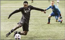 ??  ?? Sporting Kansas City forward Gerso Fernandes scores a goal past Atlanta United goalkeeper Paul Christense­n for a 2-0 lead during the second half
of an MLS soccer match on May 9 in Atlanta. (AP)