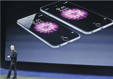  ??  ?? Apple chief executive officer Tim Cook unveils new iPhones. Two major investors in the company want Apple to add new features to iPhones and tablets that would limit the amount of time children spend staring at a screen.