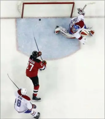  ?? JULIO CORTEZ — THE ASSOCIATED PRESS ?? New Jersey’s Patrick Maroon (17) scores on Montreal goaltender Charlie Lindgren (39) as defenseman Jordie Benn (8) looks on during the second period Tuesday in Newark, N.J. The Devils won, 6-4.