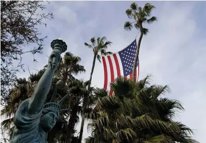  ?? Chris Carlson / Associated Press ?? A large flag flies over Ron Brindle’s tree nursery business in Huntington Beach, Calif.