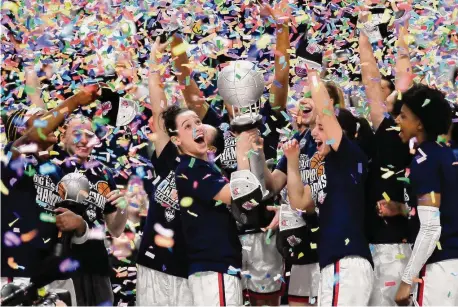  ?? Jessica Hill/Associated Press ?? UConn’s Lou Lopez Senechal holds the Big East Championsh­ip trophy while celebratin­g with teammates after a win against Villanova in the finals of the Big East Conference tournament at Mohegan Sun Arena on Monday, in Uncasville.