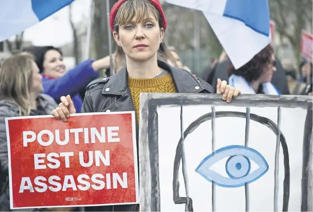  ?? ?? A woman holds a placard reading ‘Putin is a murderer’ during an alleged gathering of Navalny’s supporters near the Russian Embassy in Paris yesterday during Russia’s presidenti­al election