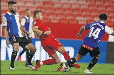  ??  ?? Rakitic, jugador del Sevilla, pugna por un balón con el jugador alavesista Manu García.
