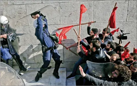  ?? REUTERS ?? Protesters clash with riot police during a demonstrat­ion outside the Parliament in Athens on Friday. Thousands of Greek protesters marched in central Athens on Friday against new reforms, including restrictio­ns on the right to strike, that Parliament...