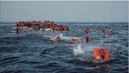  ?? ASSOCIATED PRESS FILE PHOTO ?? Migrants try to reach a rescue boat from a Spanish aid organizati­on in the Mediterran­ean Sea last summer. Tunisian authoritie­s said on Sunday that a boat believed to have been carrying about 180 passengers sank, killing dozens of people.